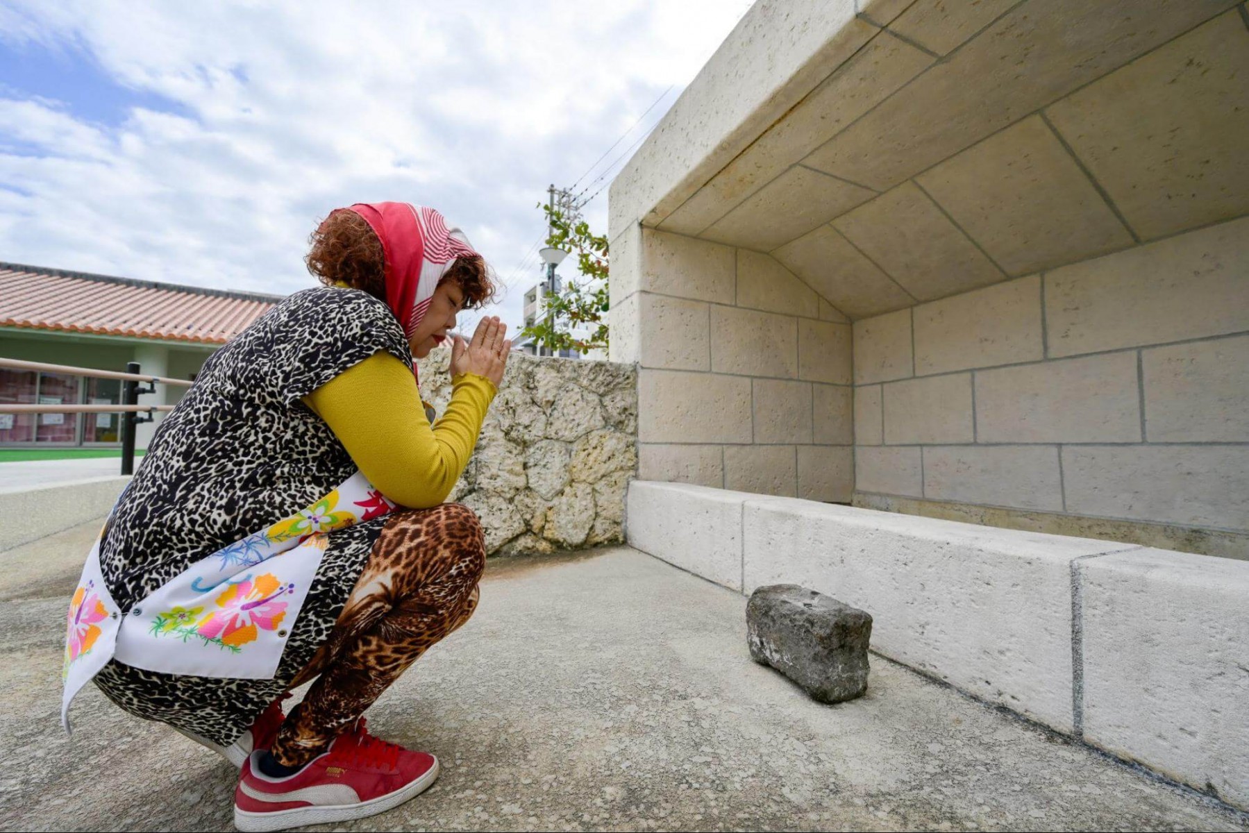 拝所に手を合わせる喜舎場 泉さん